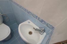 Угловой подвесной рукомойник в туалете