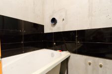 Начало укладки настенной плитки в ванной